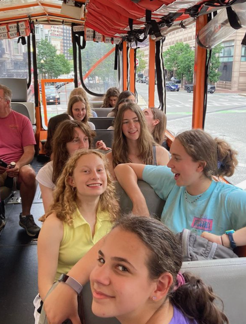 a group of teens from the Teen JUST-US program on a trolley - some are looking at the camera and others are talking to each other and looking out the windows